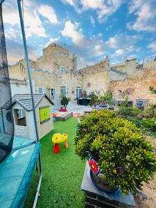 a bunch of bananas in a yard with a building at Id-dar Taz-zija Holiday Home including pool & garden in Siġġiewi