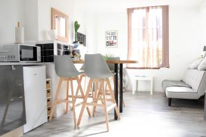 a kitchen with a table and chairs in a room at residence romi maison aeroport tillé in Tillé