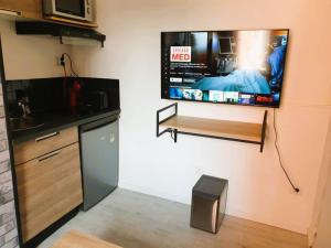 kuchnia z telewizorem z płaskim ekranem na ścianie w obiekcie STUDIO LE PETIT ATELIER - PROCHE GARE - WiFi w Amiens