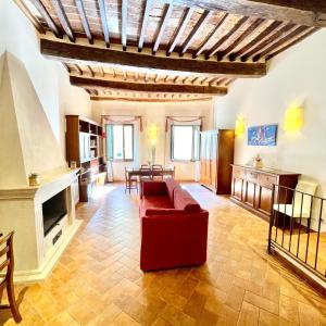 a living room with a red couch and a fireplace at La Dimora nel Corso in Montepulciano +96 photos