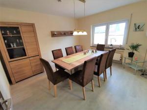 uma sala de jantar com uma mesa de madeira e cadeiras em Ferienhaus Clarissa em Allenbach