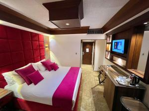a hotel room with a large bed and a flat screen tv at Petra Sella Hotel in Wadi Musa