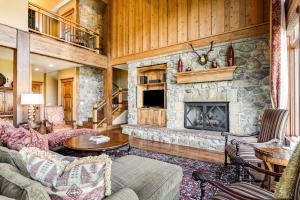 uma sala de estar com uma lareira de pedra e um sofá em Gorgeous Deer Valley mountain home minutes from the slopes em Park City