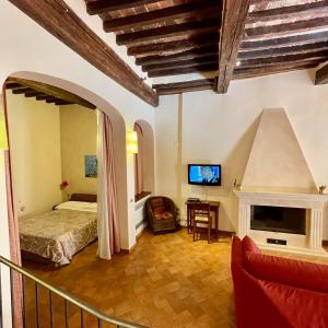 a living room with a bed and a fireplace at La Dimora nel Corso in Montepulciano