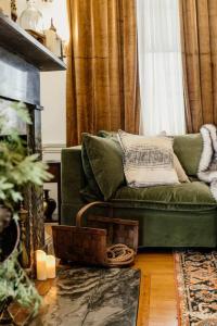 sala de estar con sofá verde y chimenea en The Jarvis Homestead - Historic Maine Mansion, en Ellsworth