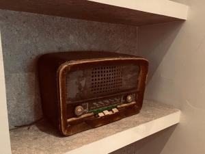 une ancienne radio assise sur une étagère dans un mur dans l'établissement Casa Lola, à León