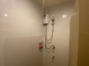 a shower in a bathroom with a phone on the wall at Malee Sirin Old Town in Ko Lanta