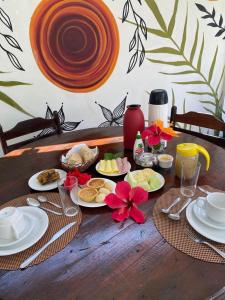 una mesa de madera con platos de comida. en Estalagem Sol de Boipeba, en Isla de Boipeba