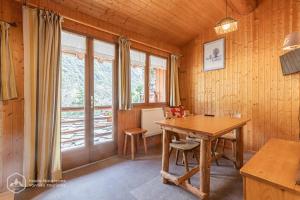 a dining room with a wooden table and a window at Agnelie 3 in Bonneval-sur-Arc