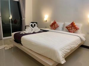 a bedroom with a large bed with two swans on it at Malee Sirin Old Town in Ko Lanta