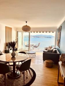 salon ze stołem i widokiem na ocean w obiekcie Les Baux 3 w mieście Sanary-sur-Mer