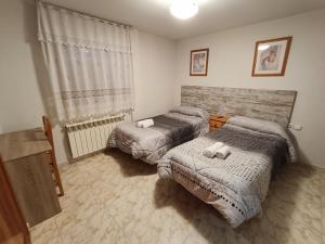 een slaapkamer met 2 bedden en een raam bij Hostal Residencia Taray in Segovia
