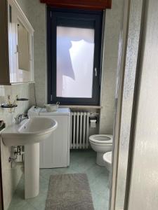 baño con lavabo y aseo y ventana en Guest House MICINI en Druento
