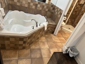 a bath tub in a bathroom with a tiled floor at hotel & spa Carré Saint-Louis in Montreal