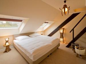 a bedroom with a large white bed in a attic at Schloss Hertefeld & Hertefeldhof in Weeze