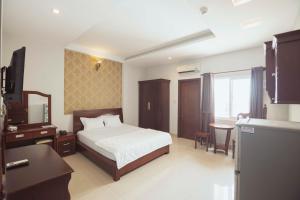 een slaapkamer met een bed, een bureau en een wastafel bij Biển Vàng - New Golden Sea in Vung Tau