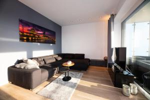 een woonkamer met een bank en een tv bij FeWo "B523" 4 Personen in Bremerhaven