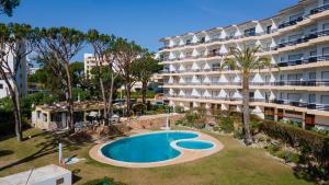 un apartamento con piscina frente a un edificio en Sweet As by LovelyStay, en Quarteira