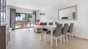 Un comedor y una sala de estar con mesa y sillas. en Sweet As by LovelyStay, en Quarteira