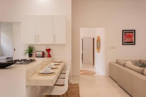 a kitchen and living room with white cabinets and a couch at VillaFour@Tsai-Tsai in Vilanculos