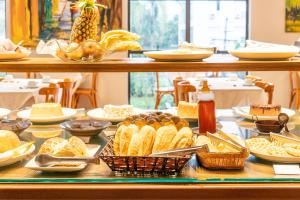 a buffet filled with different types of food on a table at Dexter Hotel - Volta Redonda in Volta Redonda