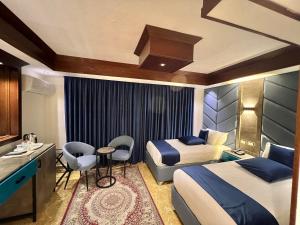 a hotel room with two beds and a desk at Petra Sella Hotel in Wadi Musa