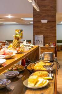 una línea de buffet con muchos tipos diferentes de comida en Dexter Hotel - Volta Redonda, en Volta Redonda