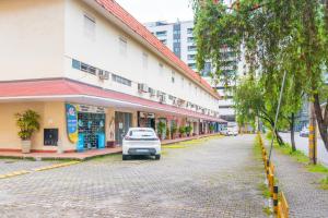 un coche blanco estacionado al lado de una calle en Dexter Hotel - Volta Redonda, en Volta Redonda