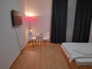 a room with a bed and a table and chairs at Piata Unirii- 1 Room Studio Apartment in Timişoara