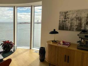 Habitación con ventanas y vistas al agua. en Amazing sea view apartment, en Aarhus