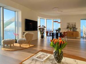 a living room with chairs and a table with a view at Amazing sea view apartment in Aarhus
