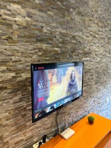 a flat screen tv hanging on a brick wall at Panorama Apartments in Tirana