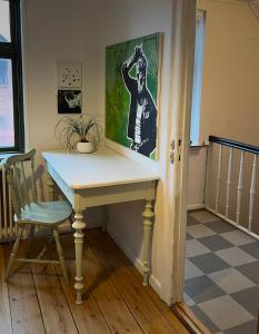 een bureau in een kamer met een stoel en een schilderij bij JM B&B in Sakskøbing