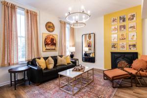 a living room with a black couch and a fireplace at The Woodford Hotel in Versailles