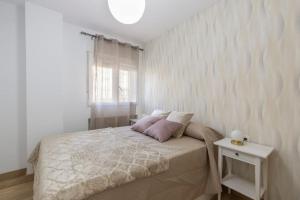 A bed or beds in a room at Neptuno Deluxe