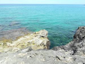 a view of the ocean from a rocky shore at La Racioppola in Ostuni