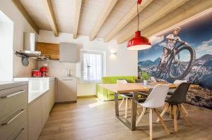 a kitchen and dining room with a table with a bike on the wall at Casa Tosca - Holiday Home in Nago-Torbole
