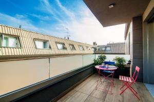 a balcony with a red table and chairs on it at Sette - by MyHomeInComo in Como