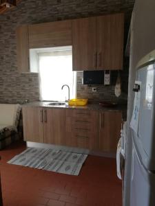 a kitchen with wooden cabinets and a sink and a window at Quinta do Girassol - AL 