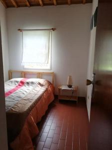 a small bedroom with a bed and a window at Quinta do Girassol - AL 