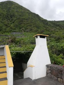 um farol branco sentado ao lado de uma colina em Quinta do Girassol - AL 