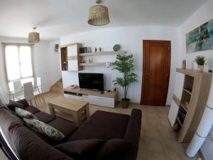 a living room with a couch and a tv at Casa Sunny in Yaiza +34 photos