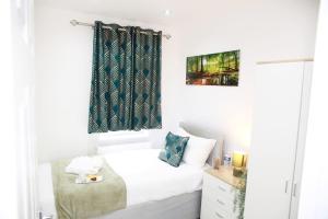 een kleine slaapkamer met een bed en een raam bij Deluxe 4-Bed House Close2 Wembley Stadium in Hendon