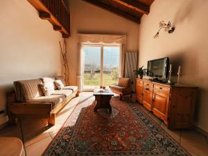 a living room with a couch and a tv at Relais diVINO in Ala