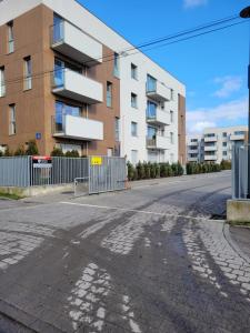 une rue vide devant un bâtiment dans l'établissement BAST 16 Apartamenty Ptak Szpital Matki Polki Szpital Kopernika Mandoria Orientarium Atlas Arena Plac Zabaw - Zamojska 20a m16 Parking, à Łódź