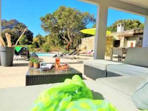 sala de estar con mesa y piscina en Arinella Villas, en Farinole