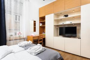 a bedroom with two beds and a flat screen tv at Apartament Vinci in Krakow