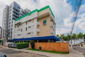 um edifício com um sinal na lateral em Coqueiros Express Hotel em Maceió