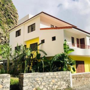 une maison jaune et blanche dans l'établissement Residencial Lela d'Fermina, à Pombas