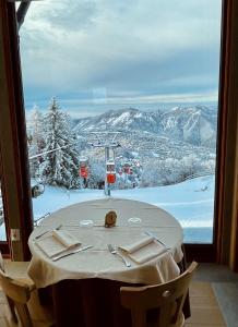 a table with a view of a snowy mountain at Resort Monte Poieto in Aviatico